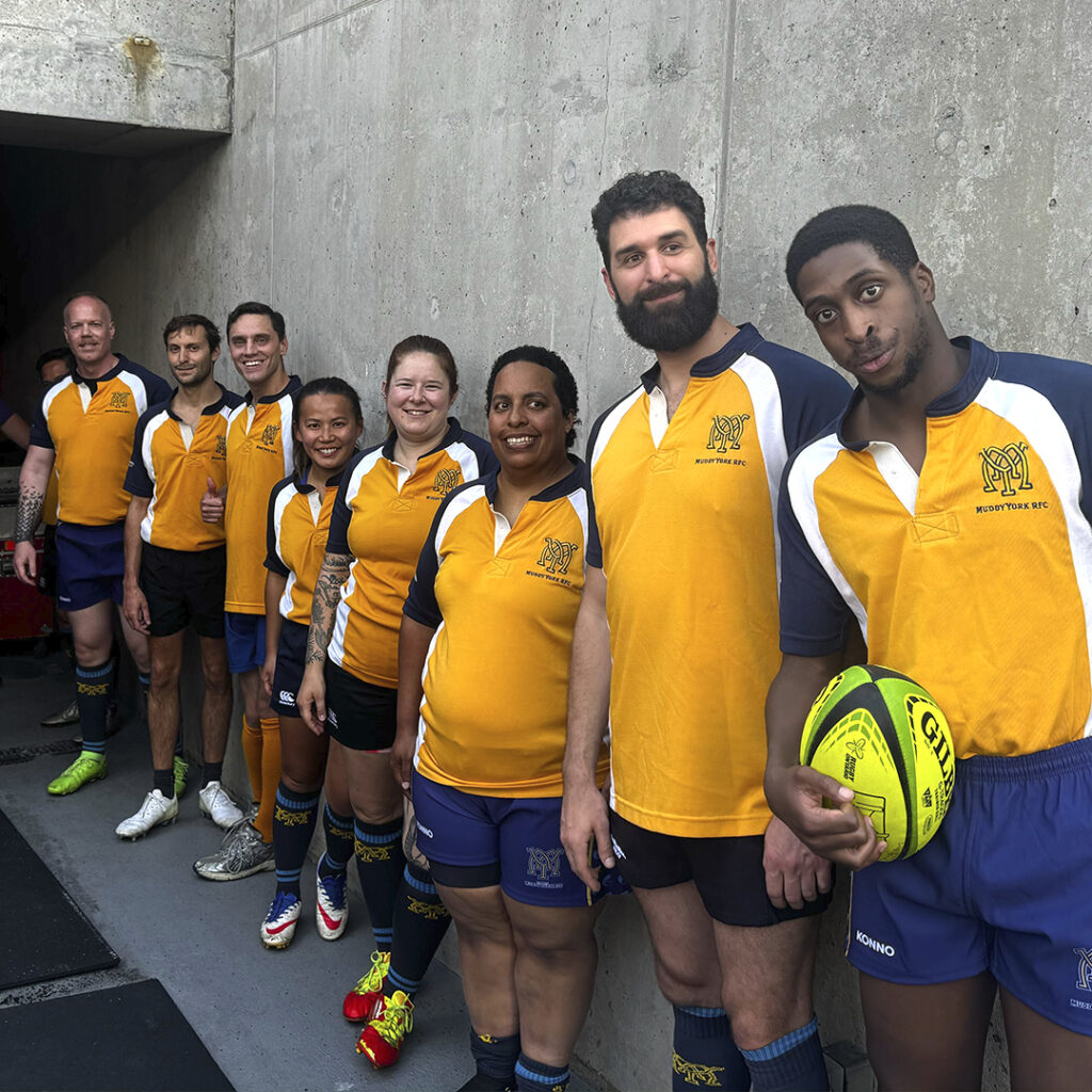 Muddy York Mixed Abilities squad posing in their yellow jerseys at the entrance to the field at TD Place in Ottawa.